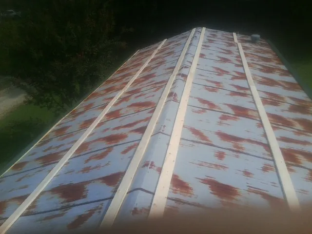 Rusted metal roof panels with new wood purlins before replacement — Storm Damage Roof Repair in Fairfax by Roofing Brothers